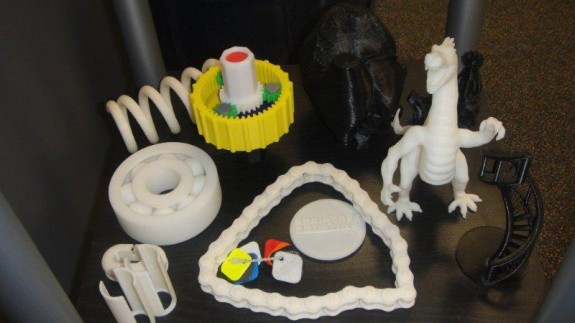 Models of chains, gears, wheels, and even a dinosaur are made at the touch of a button on the using the Dimension 1200es 3D printer at Braintree Printing in Braintree, Massachusetts.