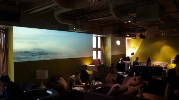 For the members' lounge of The Hospital Club in London, Open Gallery created a multiple-screen installation of video art.  Works by seven artists are featured on three large-scale projections and three small LCD monitors. Photo: Open Gallery